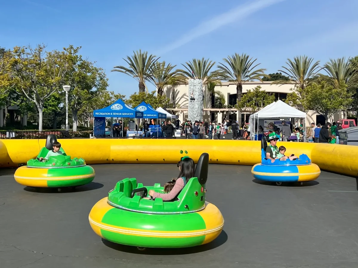 Bumper cars with a rock climbing wall in the background at the Spirit Run expo
